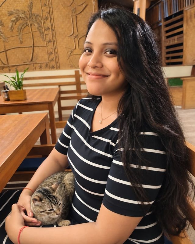 Gayatri with a tabby cat on her lap